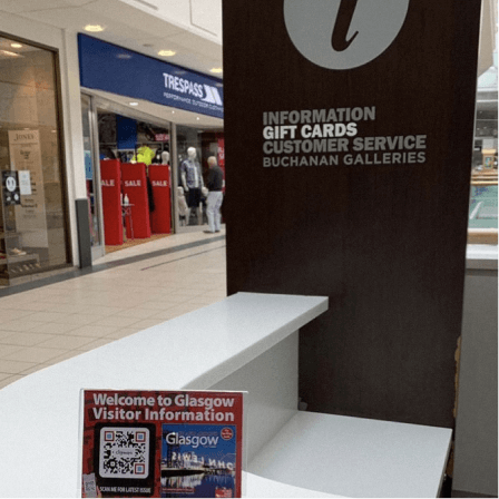Código QR impreso en un expositor de mesa de Downtown CityMaps en un punto de información que ofrece a visitantes más información sobre Glasgow.