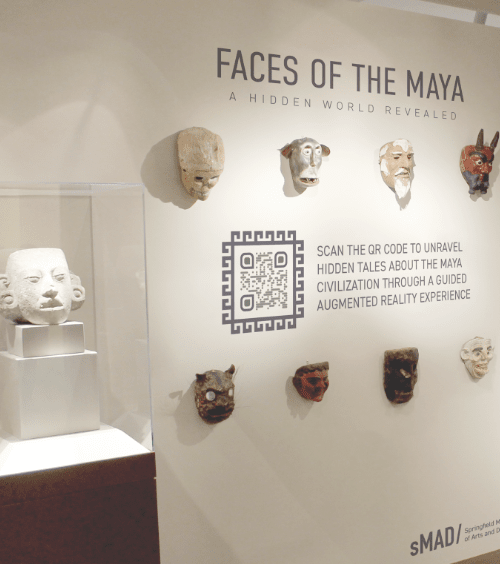 Código QR en una pared con exposiciones de arte promocionando una aplicación