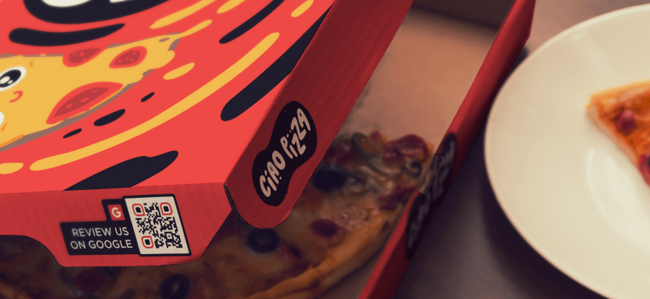 Una caja de pizza con un código QR en el lateral.