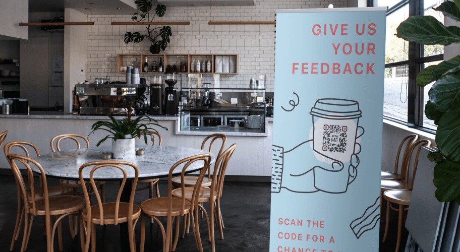 Publicidad con un código QR en una cafetería que les solicita a las personas su opinión.